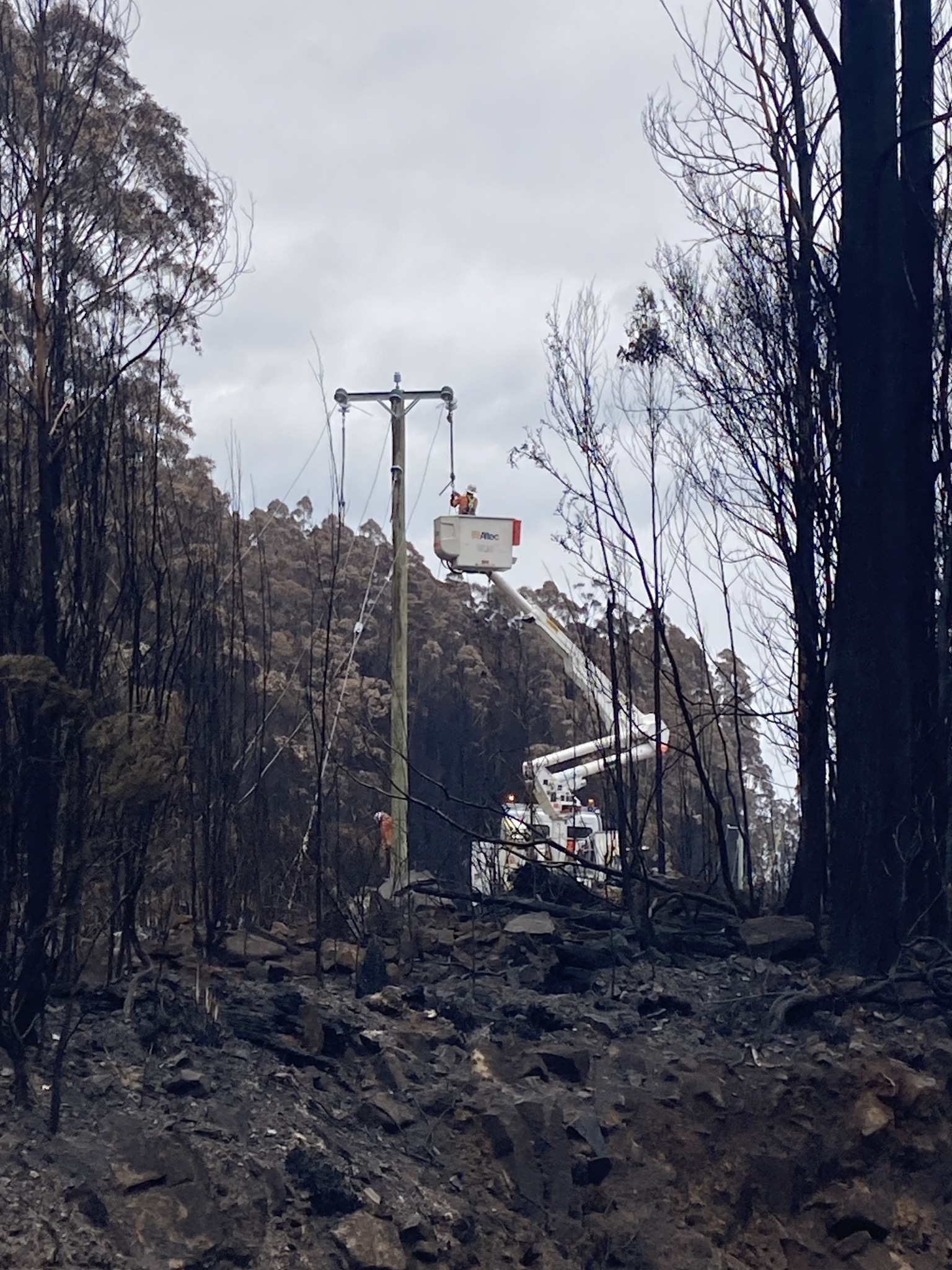 Crew in truck attending powerline in burnt-out area.