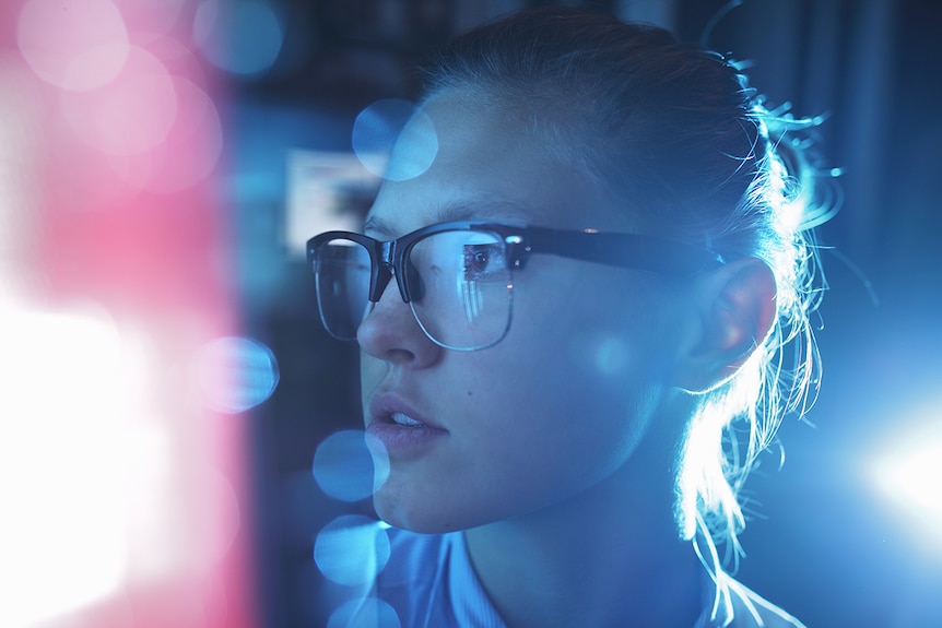 A woman IT professional looks at a computer screen.