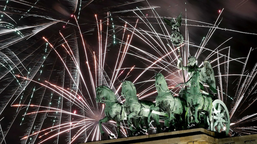 Fireworks light the sky above the Quadriga at the Brandenburg Gate