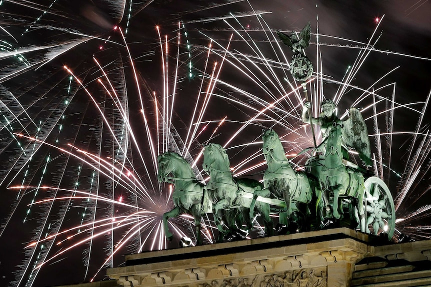 Fireworks light the sky above the Quadriga at the Brandenburg Gate