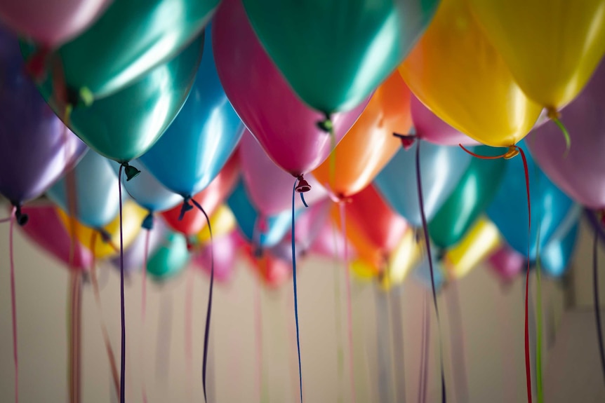 A photo of helium balloons at a birthday celebration.