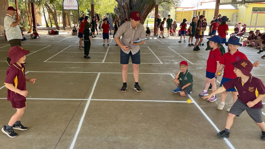 school children playing handball in red and yellow uniforms