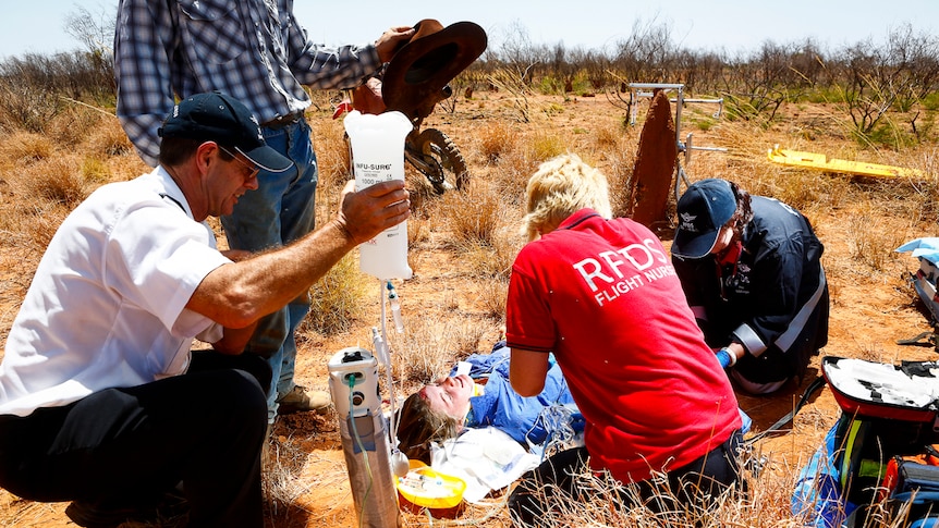 RFDS team work on a patient on the ground at a property near Mt Isa.