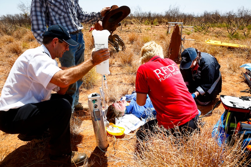 RFDS team work on a patient on the ground at a property near Mt Isa.