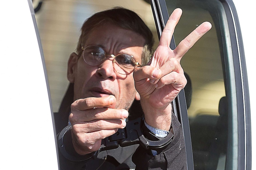 Seif Eldin Mohamed Mustafa flashes the "V" for victory sign as he leaves a court in Larnaca.