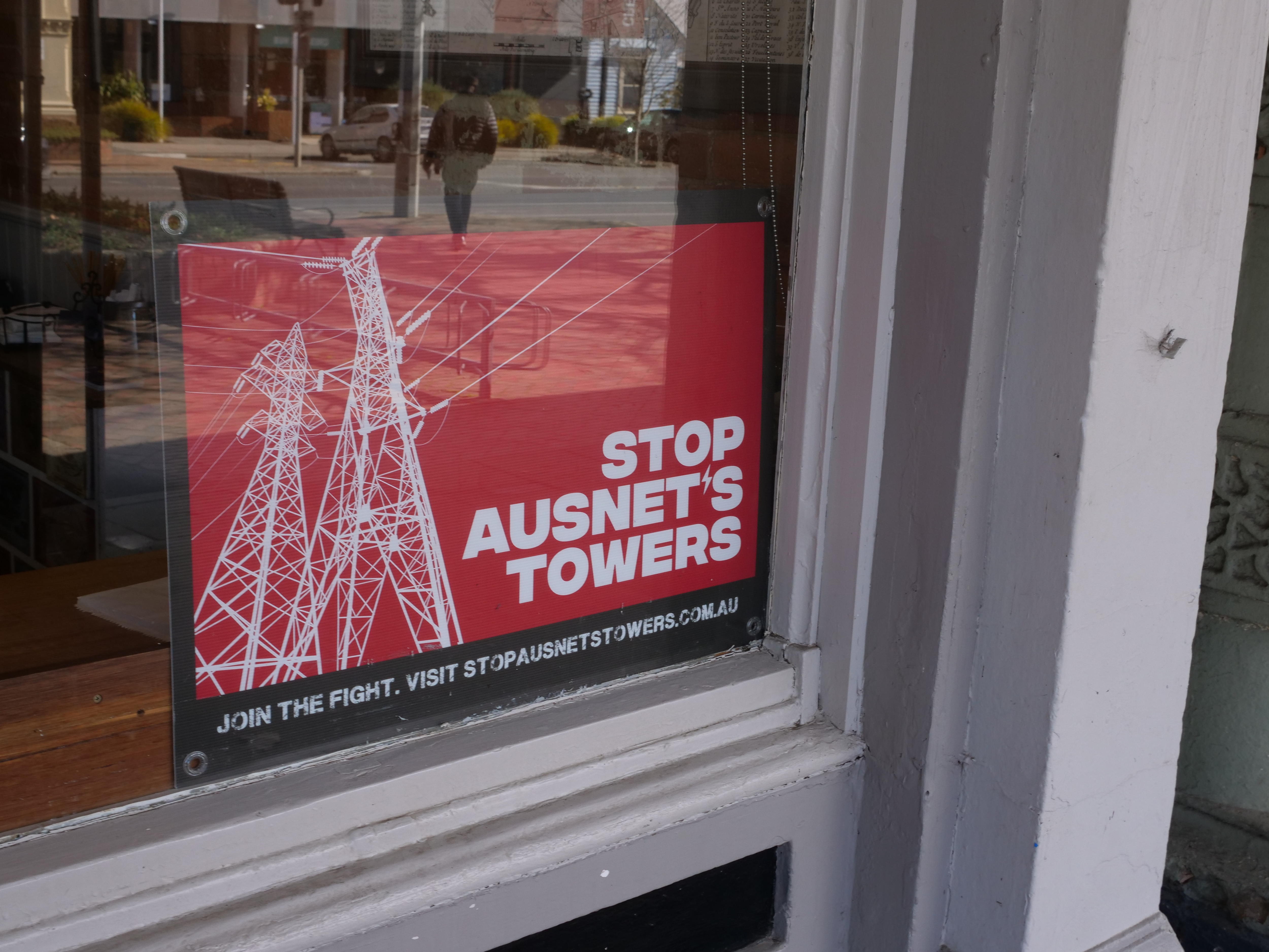 red sign which reds stop ausnet's towers in window of Creswick business