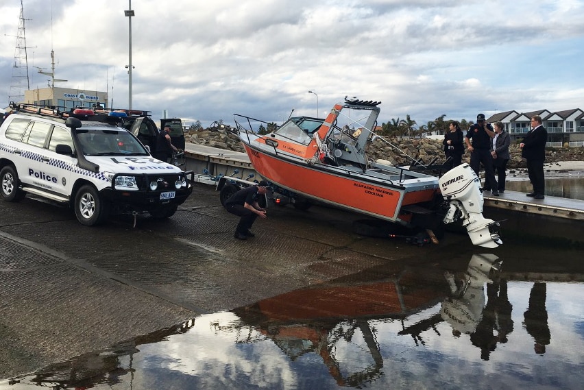Boat returned to shore, with police standing nearby