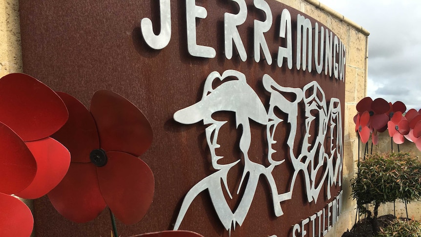 A large metal welcome sign reads "Jerramungup, Soldier Settlement", surrounded by red poppies.