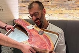 man holding a giant steak
