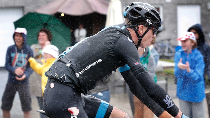 Chris Froome rides in torn cycling outfit after falling on stage five of the 2014 Tour de France.
