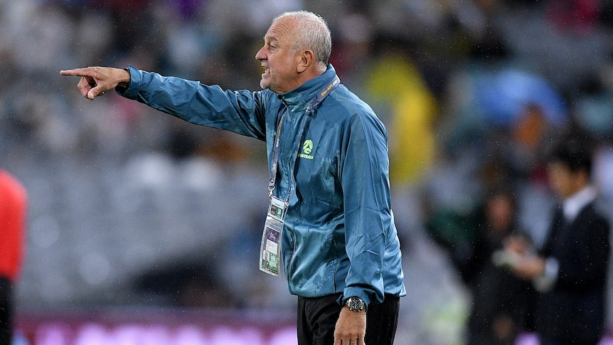 Socceroos coach Graham Arnold points with a finger on his right hand during a match against Japan.