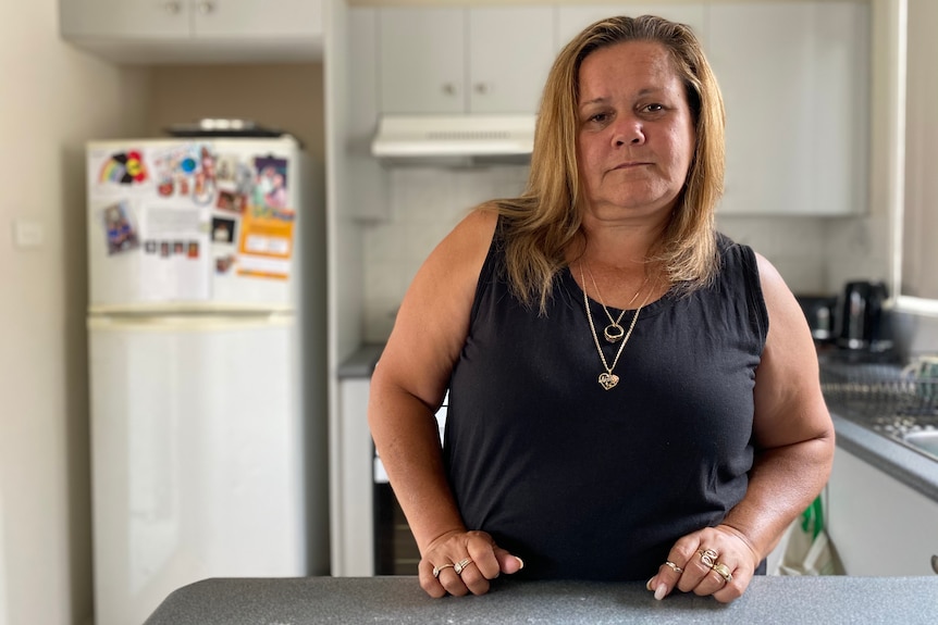 a woman standing in a kitchen and looking