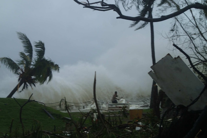 A man runs from a high wave