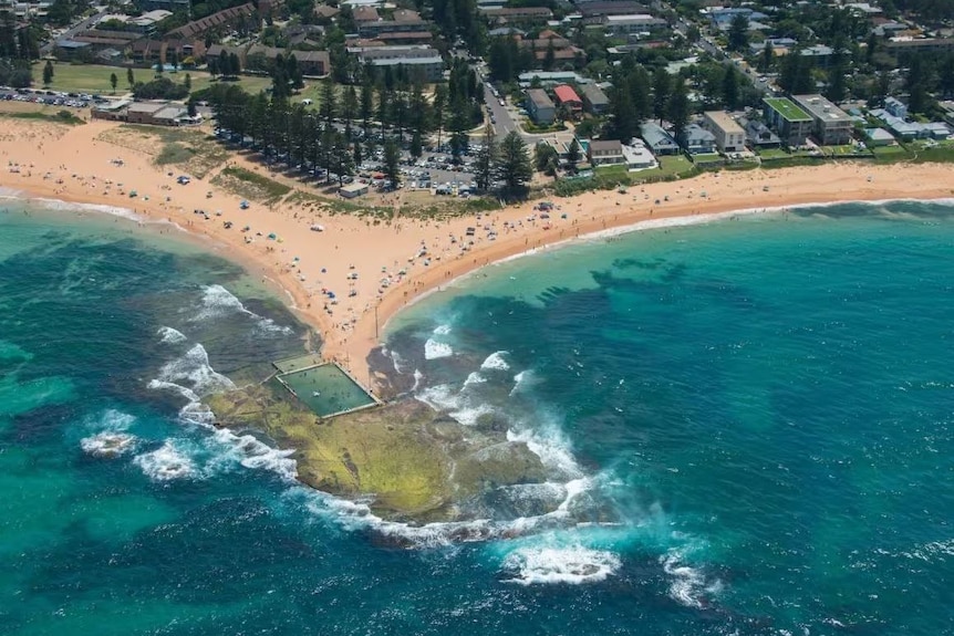 Aerial view of beach featuring a small headland with a tidal swimming pool