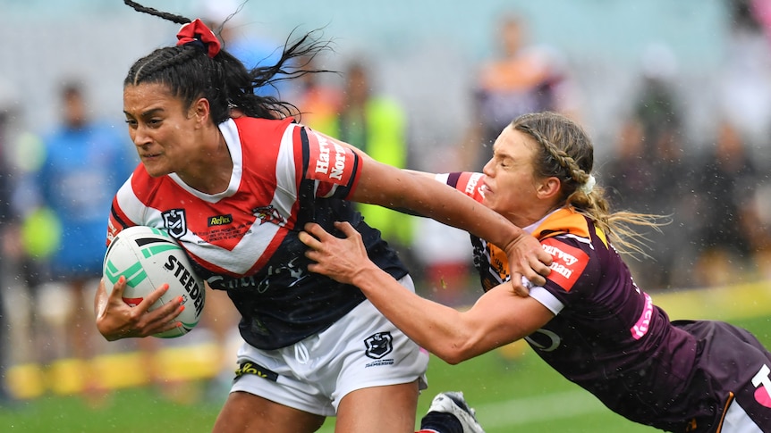 Sydney Roosters player Yasmin Meakes fends off a tackle by Brisbane Broncos' Tarryn Aiken