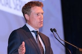 A mid shot of Federal Minister for Social Services Christian Porter speaking at a podium.