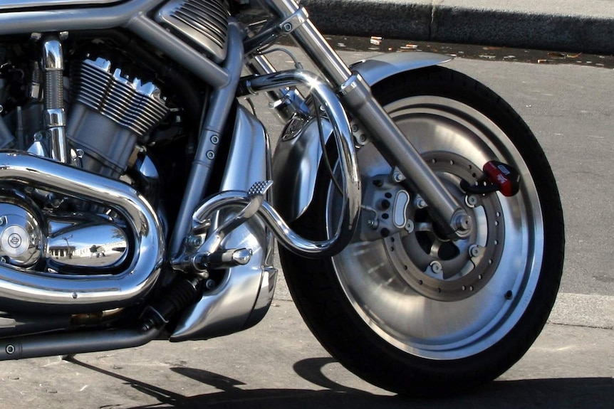 Close-up photo of the front wheel of a Harley Davidson motorbike.