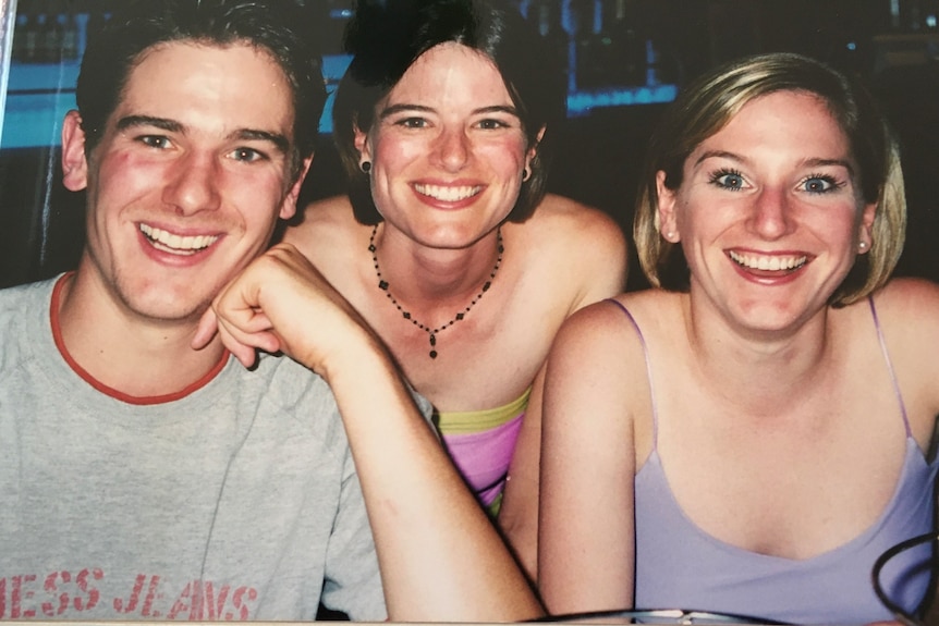 Three siblings photographed smiling next to each other