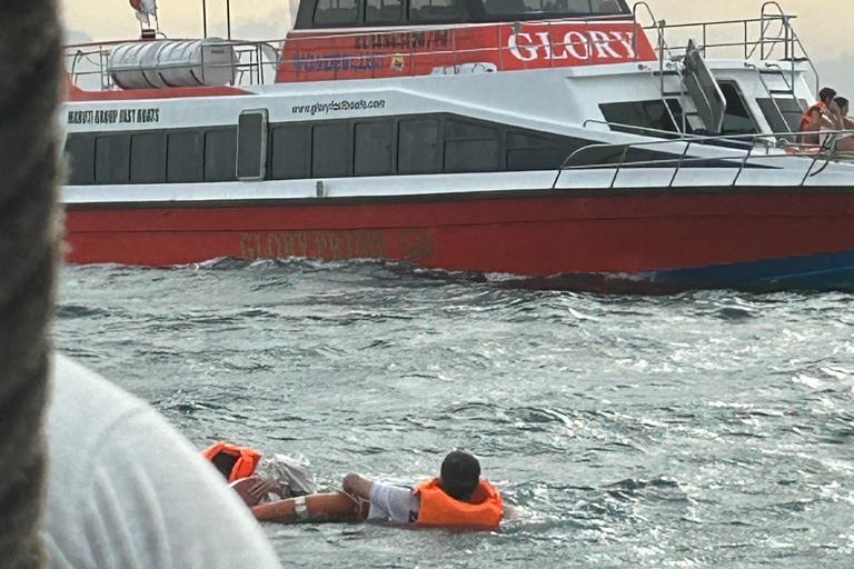 Tourists wearing life jackets float in the sea after their boat sank off the coast of Bali.