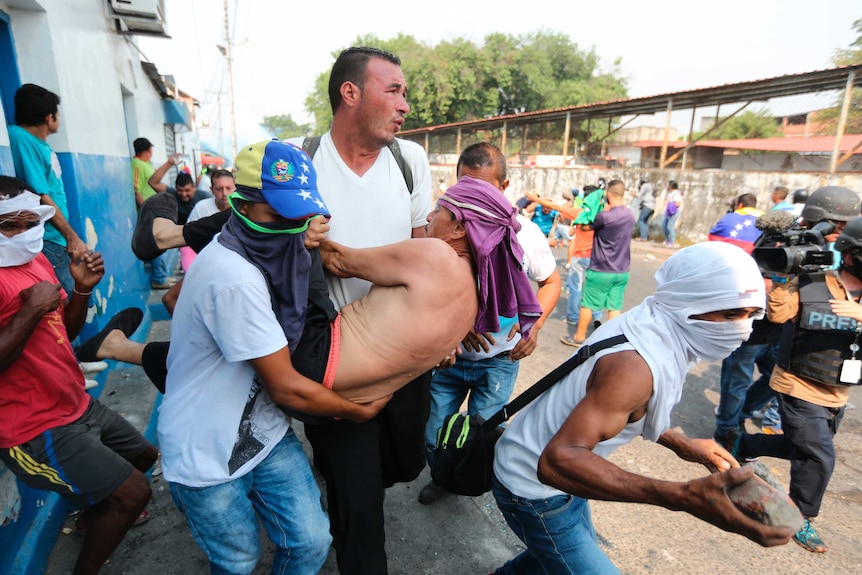 A man is carried away after he was overwhelmed by tear gas during clashes with Venezuelan soldiers.
