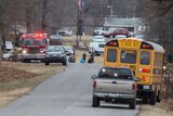 A fire truck and school bus are seen among other vehicles on the side of a road.