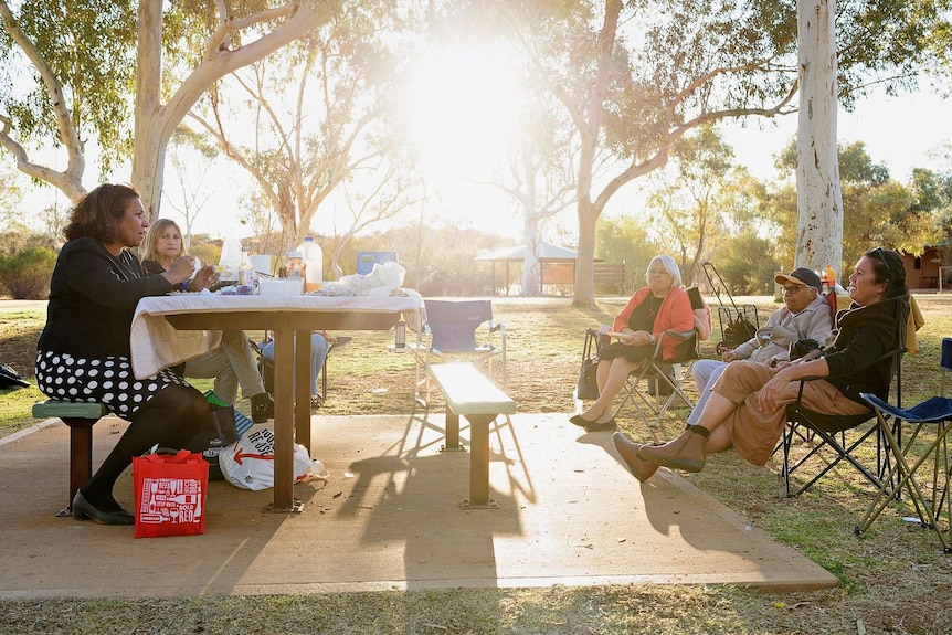 Leanne Liddle sits with her aunts at a family BBQ at sunset.