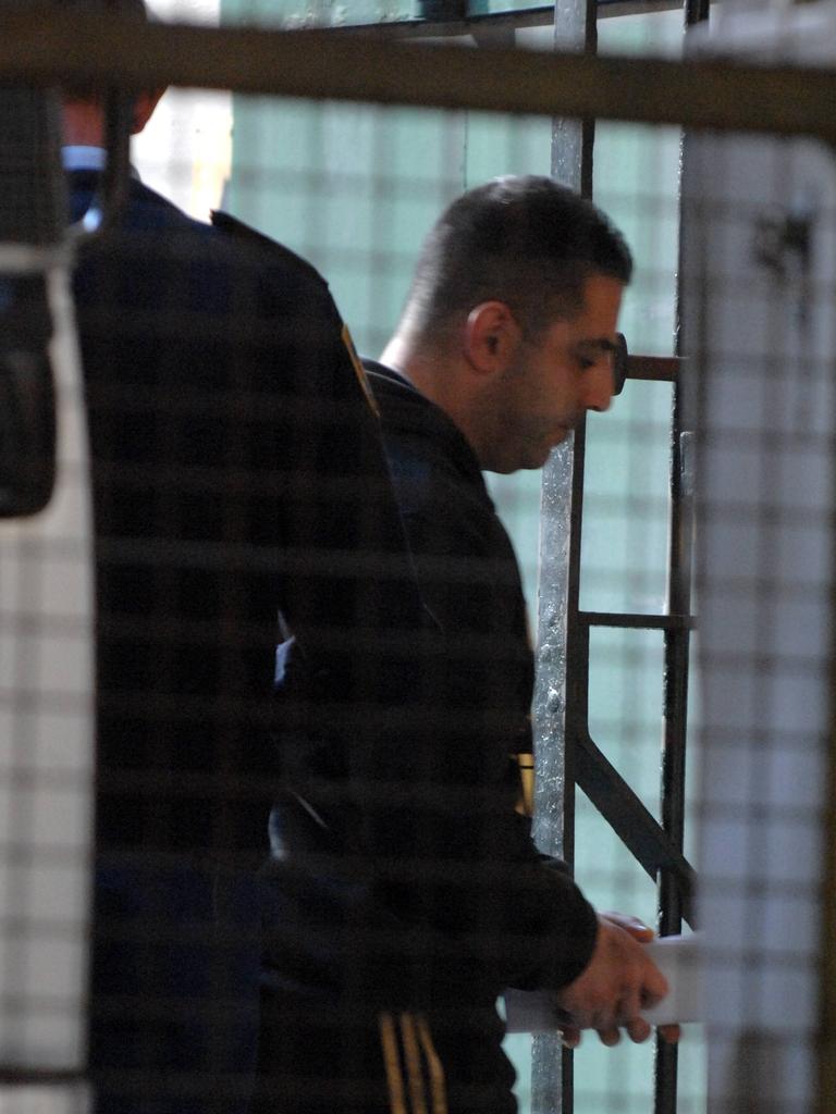 Side shot of man being led by police