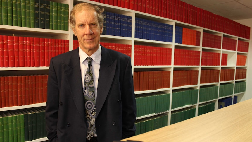 Lawyer Greg Mead stands in front of book shelves.
