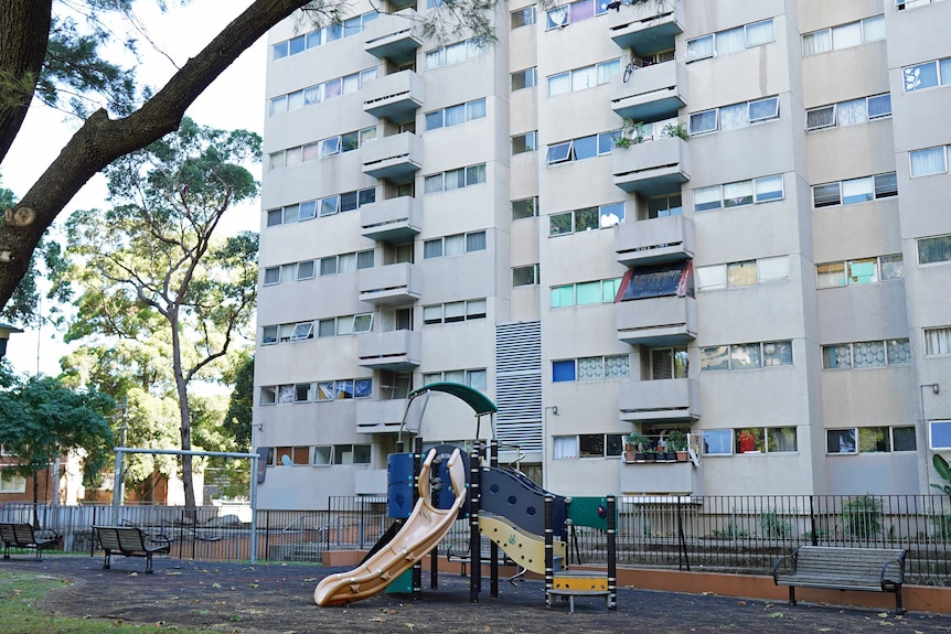 A playground in front of an apartment block.