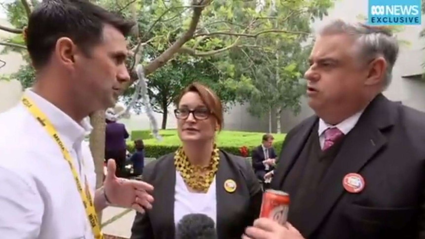 ABC journalist Matt Wordsworth speaks to Labor politician Brian Mitchell while Labor politician Justine Keay looks on.