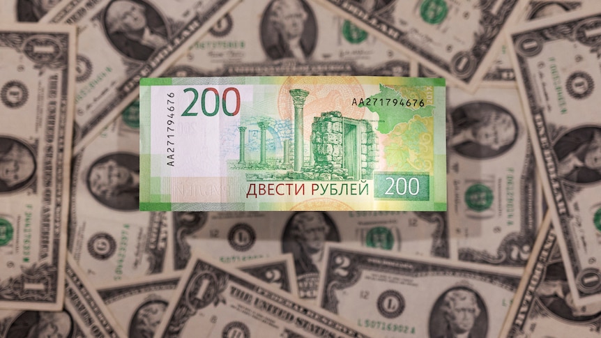 Russian rouble banknote is placed on US dollar banknote