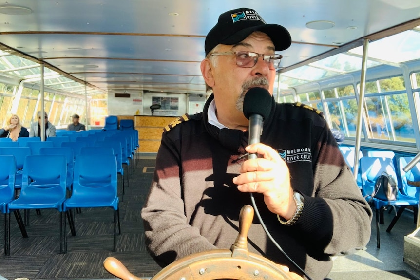 Captain Jimmy 'Whisker' steers the boat down the Yarra River in Melbourne.