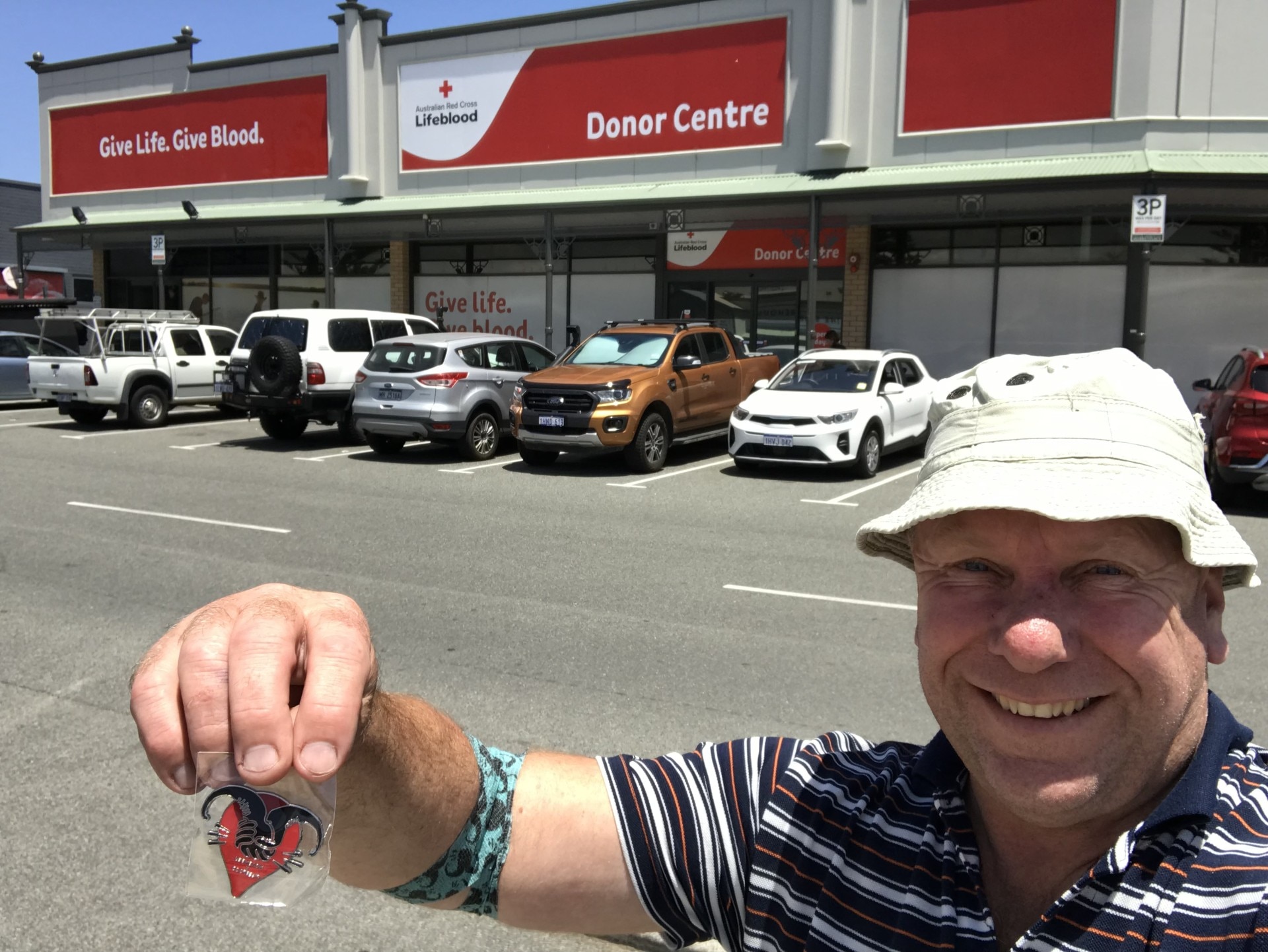 Trevor, a middle aged man, holds a Lifeblood keyring in a carpark
