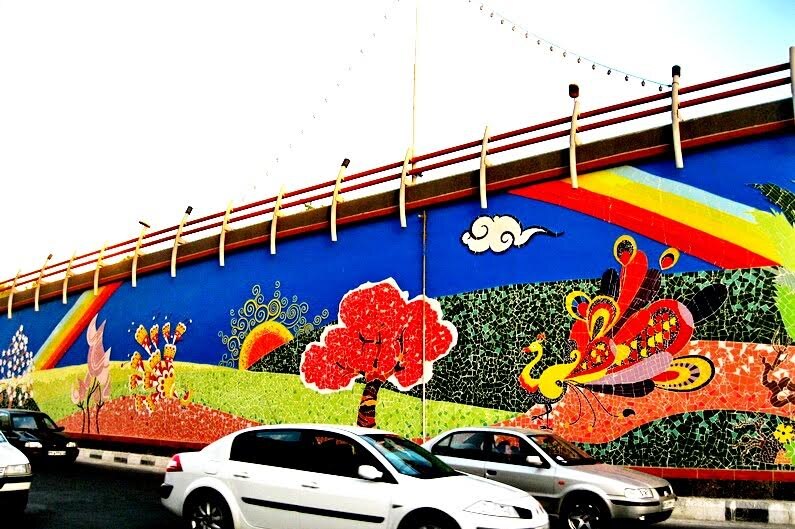 Cars drive by a mosaic mural by Mahdi Jahangirzadeh in Iran