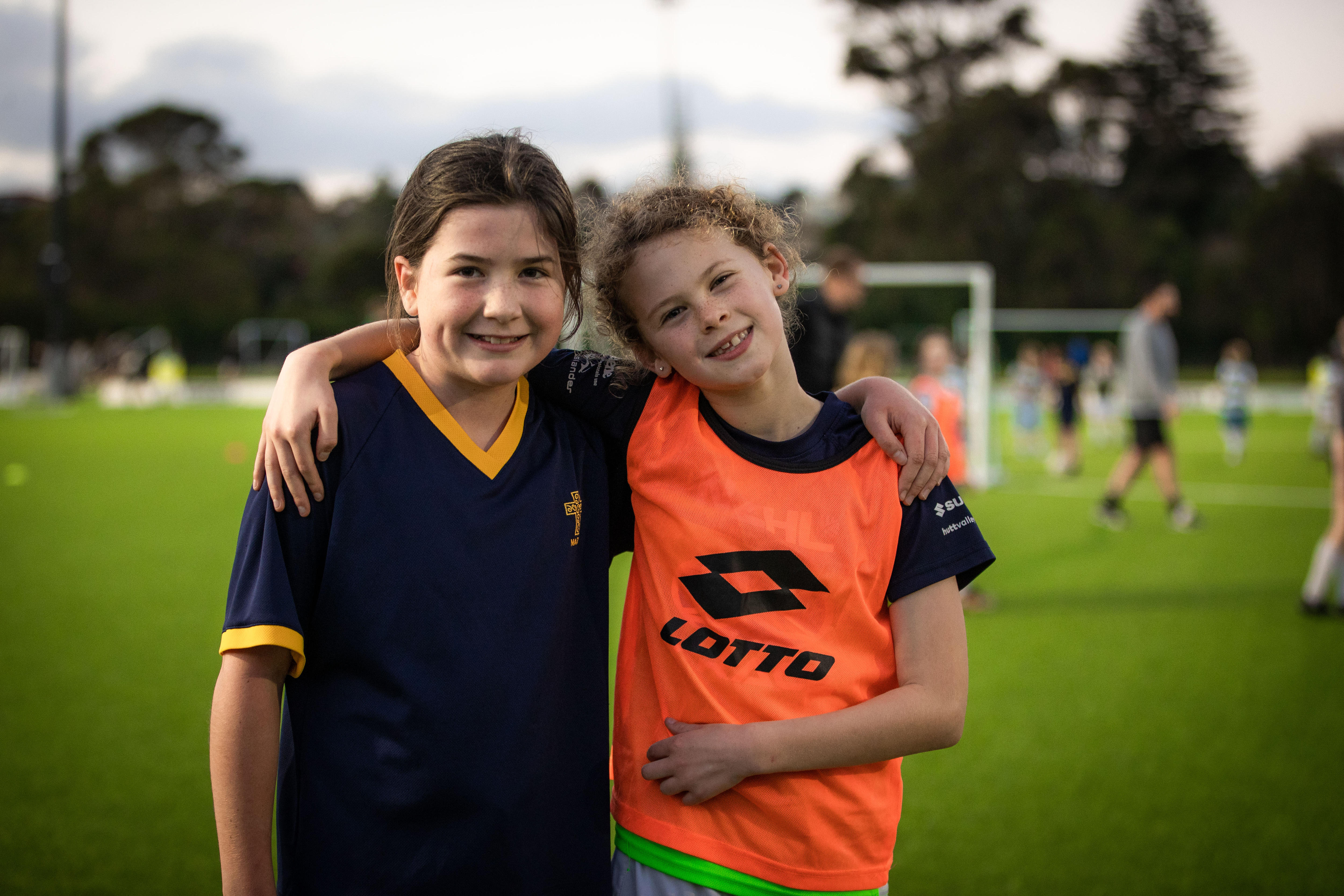 Two young female Football Ferns fans pose for a photo at a training session in New Zealand.