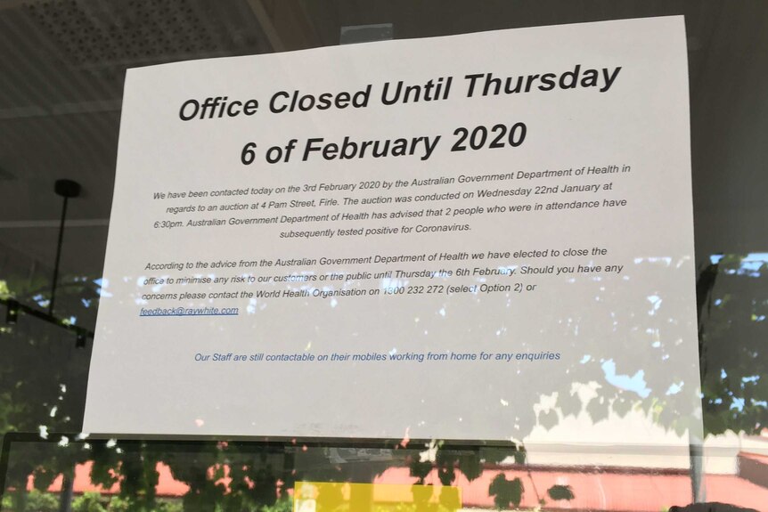 A sign announces the temporary closure of a Ray White real estate office.