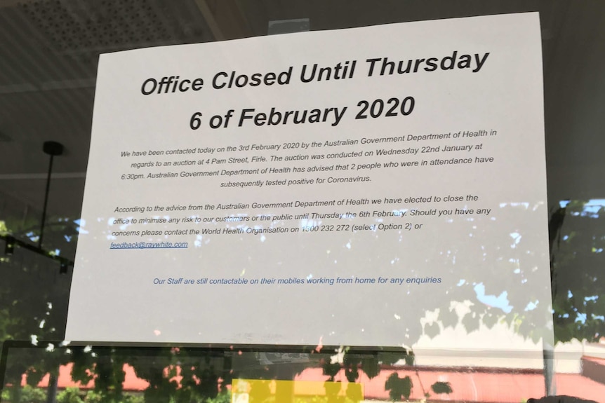 A sign announces the temporary closure of a Ray White real estate office.