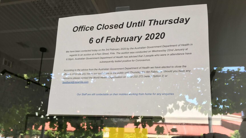 A sign announces the temporary closure of a Ray White real estate office.