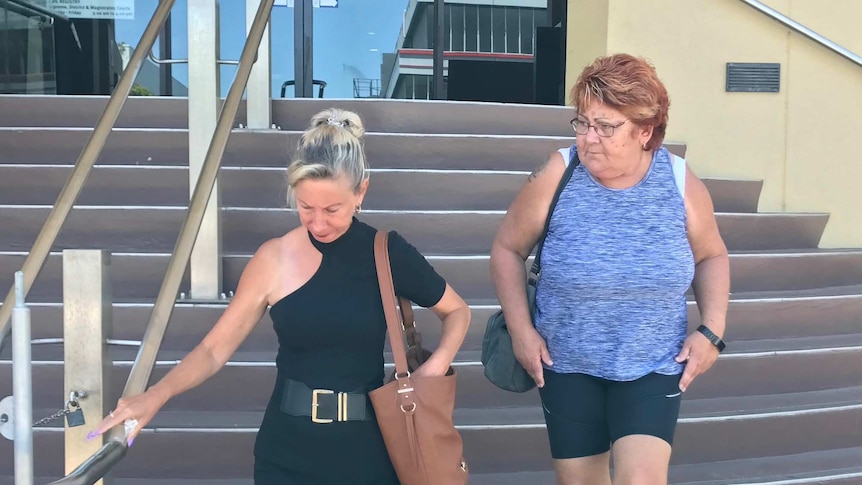 Two women walk down stairs outside a courthouse in Mackay.