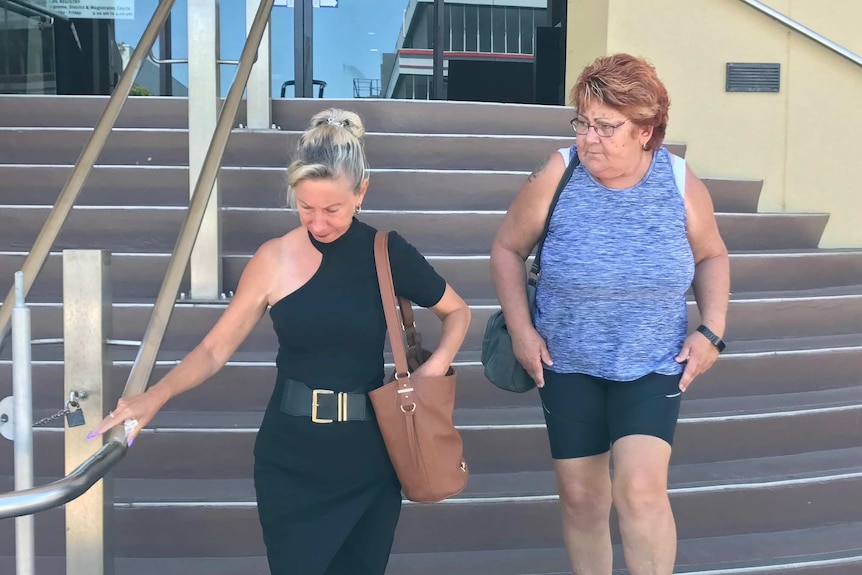 Two women walk down stairs outside a courthouse in Mackay.