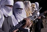 Five Pakistani Taliban fighters with their faces covered holding guns.