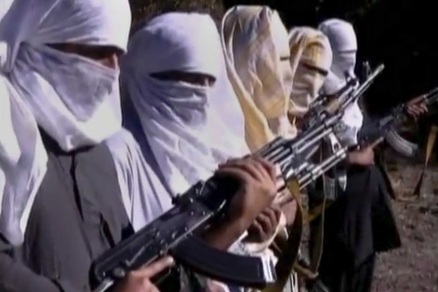 Five Pakistani Taliban fighters with their faces covered holding guns.