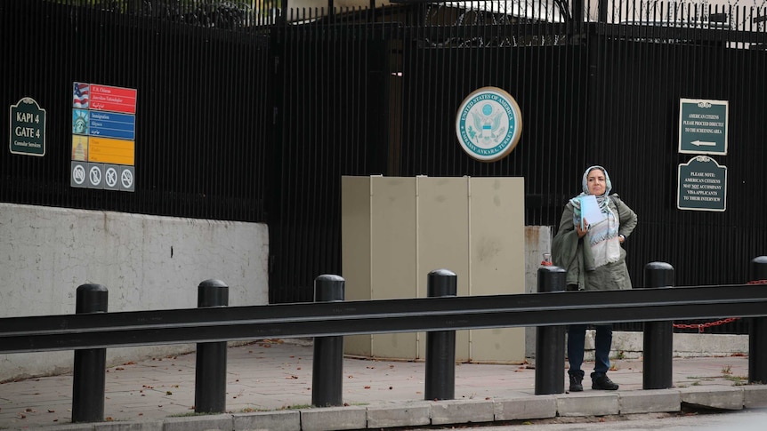 A woman waits in front of the visa application office entrance in Ankara.