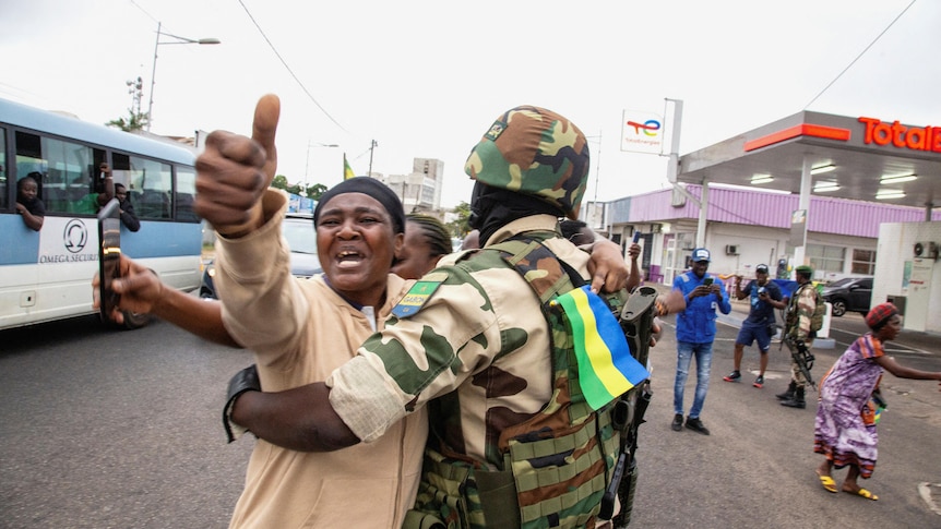 A woman embraces a soldier as she celebrates in Gabon.