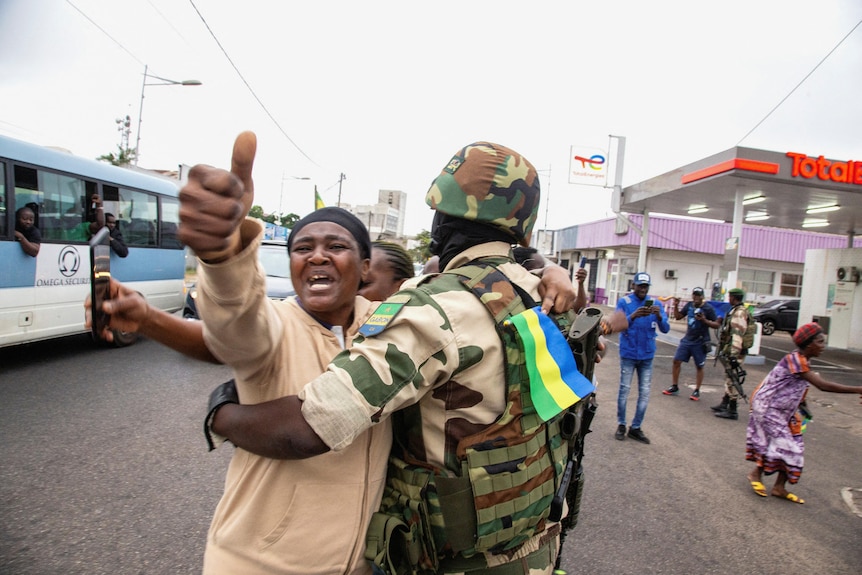 A woman embraces a soldier as she celebrates in Gabon.