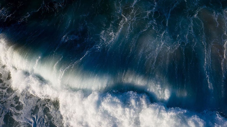 A drone photo of dark ocean waves.