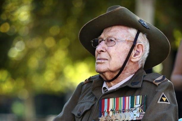 Norvyn Wallace "Bluey" Stevens sitting in a wheelchair wearing his Army uniform