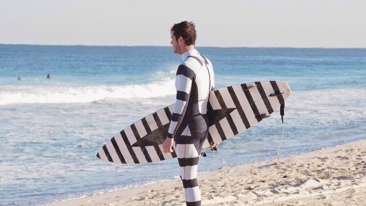 Black and white swimwear and boards are being designed by Australian companies to deter sharks while surfing.