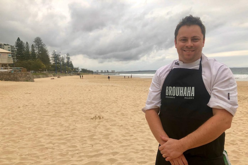 James Ostridge standing on the beach.