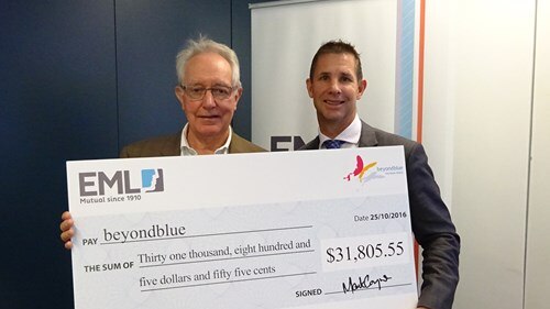 EML chief executive Mark Coyne hands over a donation to mental health advocacy group Beyond Blue in 2016.